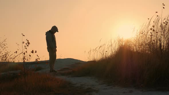 A Man With His Head Bowed Against The Sunset, A Sad Young Man. Problems Or Depression In A Man alt