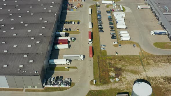 Park with Warehouse Loading Hub with Many Trucks Aerial View alt
