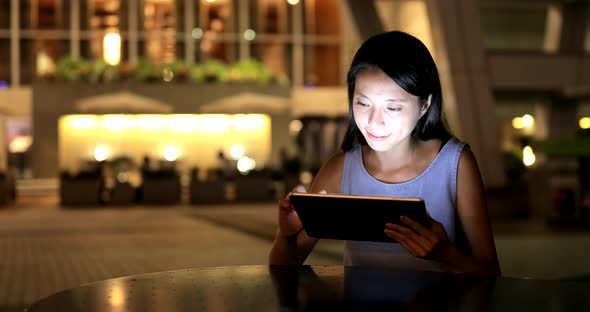 Asian Woman use of tablet computer at night 