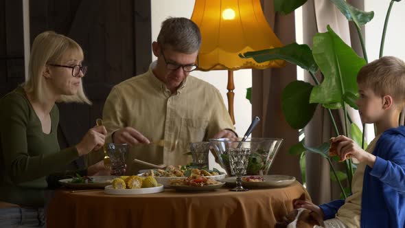 family having dinner at the table indoor at home alt
