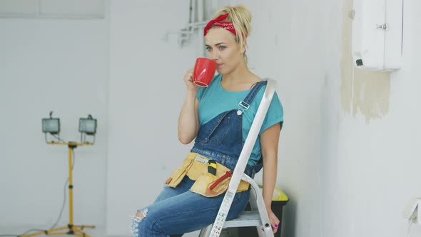 Female Sitting with Drink on Stepladder alt