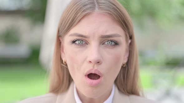 Close Up of Face of Young Businesswoman Looking Shocked at Camera alt