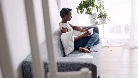 Solitary woman reading a book at home alt