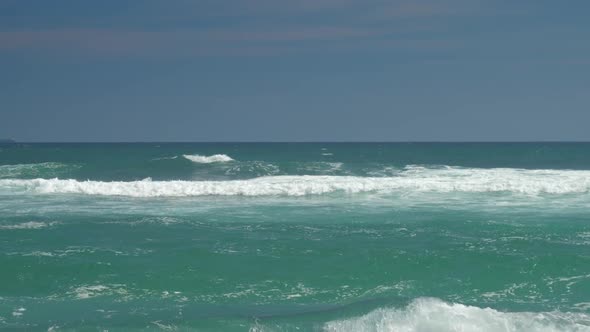 Azure Ocean with Rolling Waves Against Blue Sky Slow Motion alt
