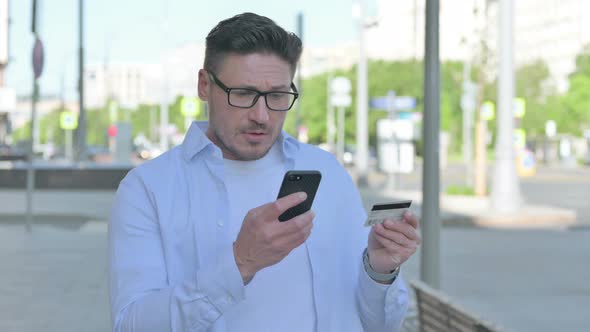 Man Having Online Payment Problem Via Smartphone Outdoor alt