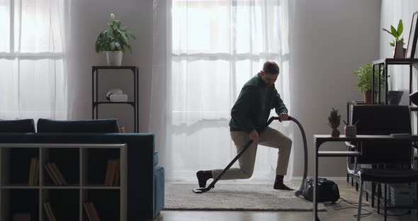 Funny Guy Is Dancing with Vacuum Cleaner in Apartment Cleanup at Home and Having Fun in Modern alt