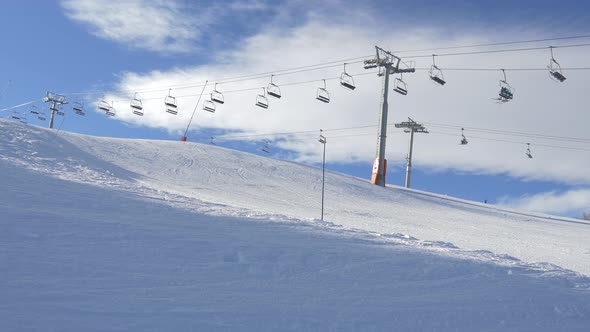 Chairlifts running above a ski slope alt