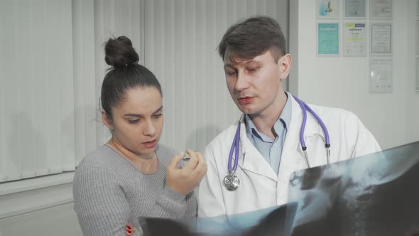 Doctor Explaining Xray Scanning Results to His Female Patient alt