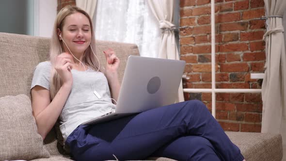 Woman Enjoying Listening Music on Laptop Relaxing at Home alt