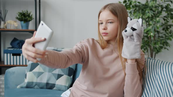 Joyful Kid Taking Selfie with Glove Puppet Posing for Smartphone Camera Having Fun at Home alt