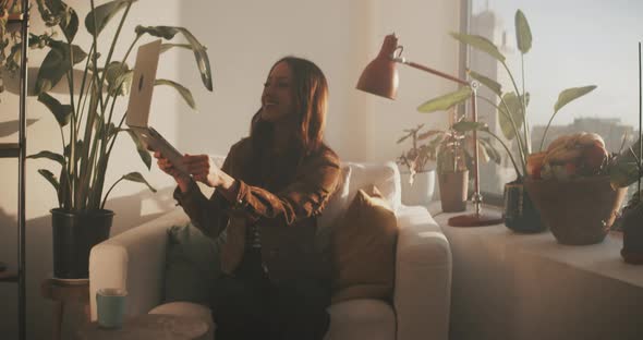 Woman lifts laptop to show the view from her apartment window alt