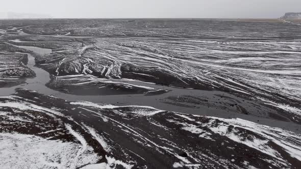 Winter landscape in Iceland with white stripes of snow and black sand