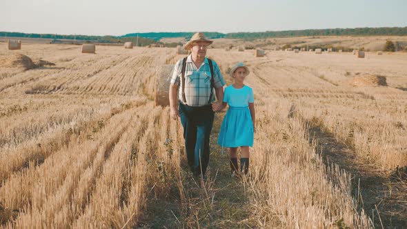 Little Girl with Grandfather in Field Haystacks, Grandfather Farmer Is Teaching the Younger alt