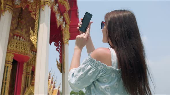 Young Woman Touirist Taking Photos While Sightseeing Buddhist Temple alt