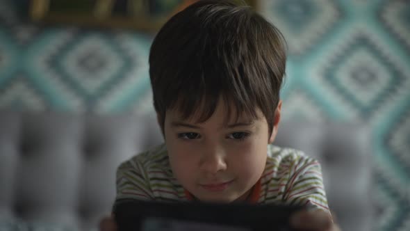 The Boy is Actively Playing Smartphone Alone in the Room