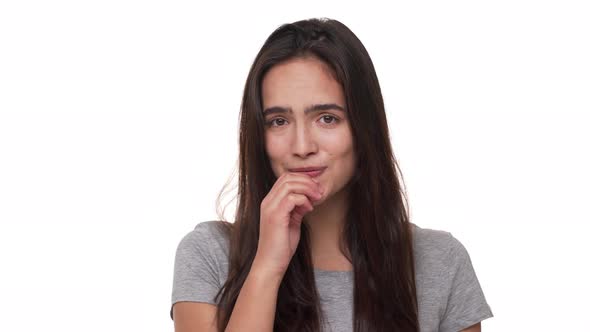 Portrait of Shy Cute Female Model with Long Dark Hair Smiling at Camera Hesitating Feeling alt