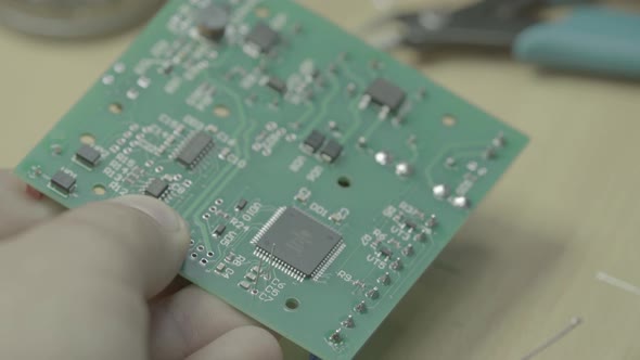A Worker Is Working on the Production of an Electronic Board. Close-up. alt