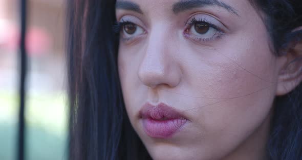 worried moroccan woman lost in her thoughts opens her eyes and looks down alt