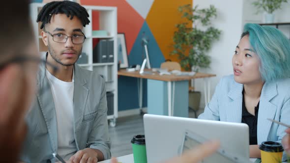 Diverse Group of Joyful Young People Discussing Colors Working with Design Project in Office alt