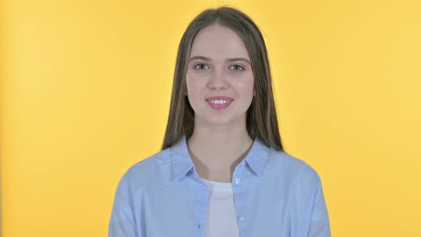 Casual Young Woman Saying Yes By Head Shake, Yellow Background alt