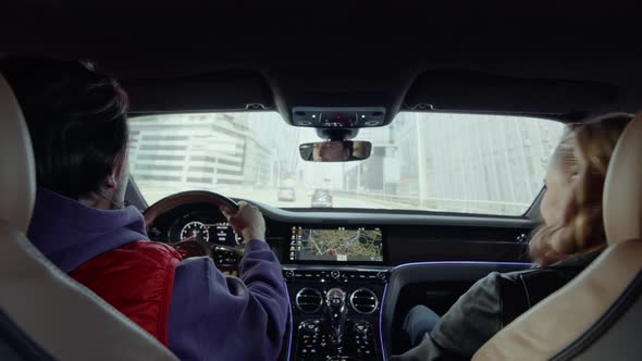 The driver driving the car turned up the volume of the music, and the passenger is dancing.