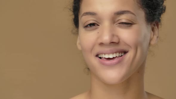Beauty Portrait of Young African American Woman Smiles and Winks Coquettishly alt