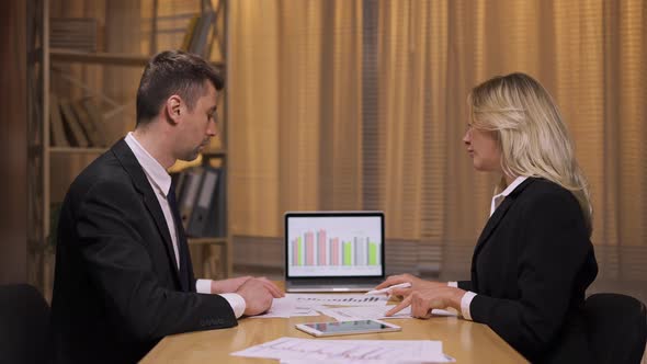 Business Partners Analyze Stock Market and Team Strategy in an Office Meeting alt