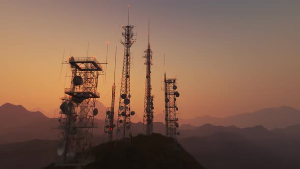 Antenna complex on a hill flythrough. Tall masts or towers during sunset. alt