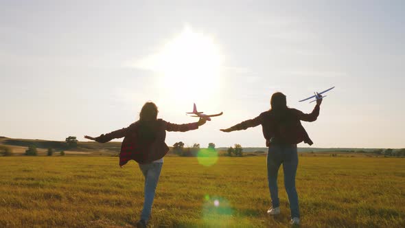 Children Play Toy Airplane. Teenagers Want To Become Pilot and Astronaut. Happy Girls Run with Toy alt