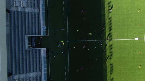 Aerial top-down rising over training football team at Studenternas Uppsala stadium, Sweden alt
