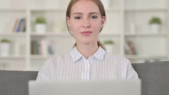Portrait of Young Woman with Laptop Looking at the Camera alt