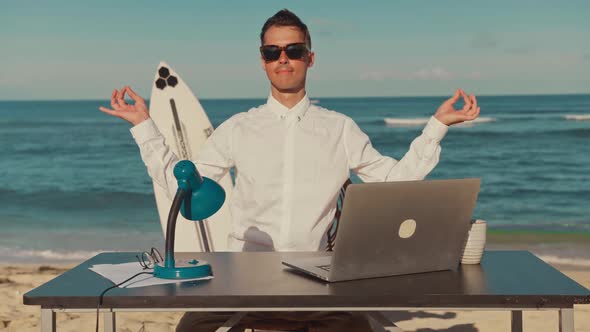 Calm Businessman Relaxing Meditation Practicing at the Workplace on the Beach alt