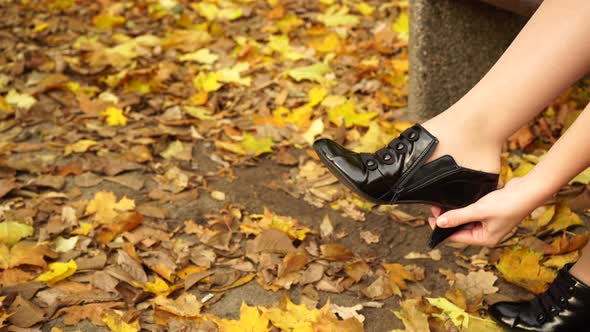 Woman Putting On Black Shoe On Feet