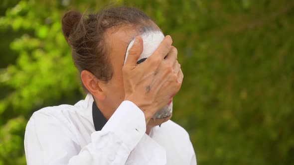 Close-up of a Mime Wipes Her Makeup alt