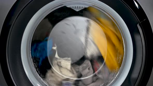 The Washing Machine Washes Women's Clothes, A Black Washing Machine Close Up. alt