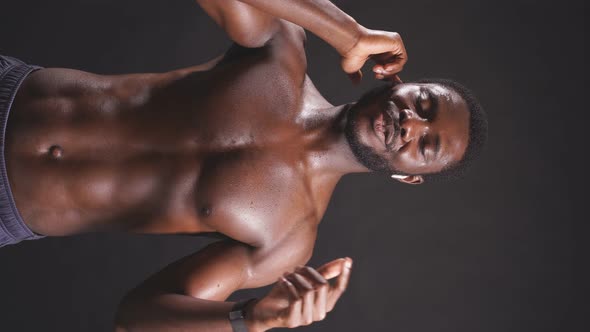 Athletic Man with Good Abs on an Isolated Dark Background