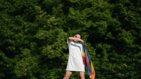 Young Woman Waving LGBT Pride Flag in the Park alt