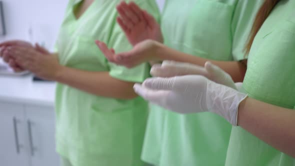 Three Unrecognizable Women in Laboratory Uniform Clapping Standing in Medical Clinic Indoors alt