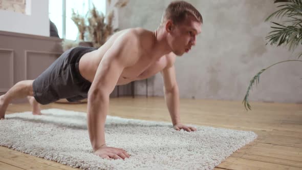A Young European Man Works Out on a Wooden Floor