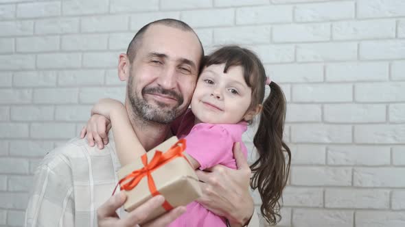 Happy daughter hugs father on holiday. alt