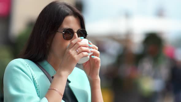 Adorable Tourist Young Woman Smiling Drinking Coffee Outdoor Enjoying Cityscape Medium Closeup alt