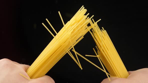 Breaking spaghetti on black background Closeup Slow motion video