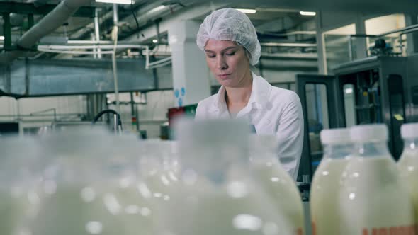 Female Employee Is Inspecting Dairy-production Process at a Food Factory alt