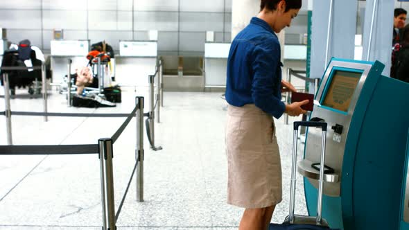 Female commuters using airline ticket machine alt