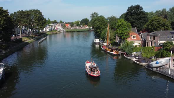 A pleasure boat sails up the Vecht at Weesp in Netherlands alt