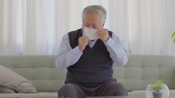 Happy Asian Elderly or Seniors man wearing medical mask to prevent coronavirus cross arms alt