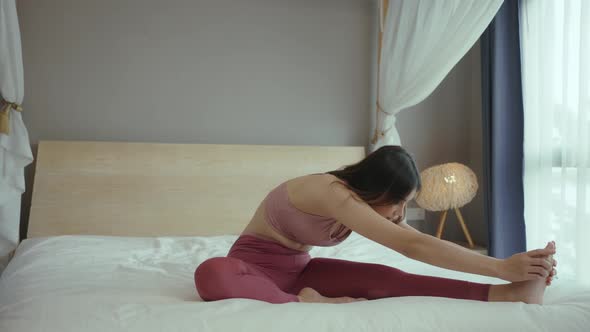 Woman exercising warming up and practicing stretching in bedroom enjoying morning fitness workout. alt
