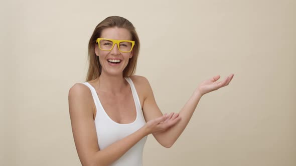 Woman Wearing Yellow Glasses Presenting with Her Palms Open