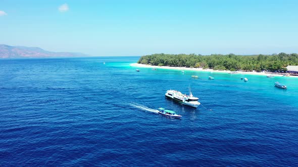 Boats and yachts fill the beautiful bay of the island with blue azure water washing white sandy beac alt