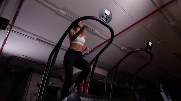 Sporting Girl in White Top and Black Leggings Running on Treadmill in the Gym